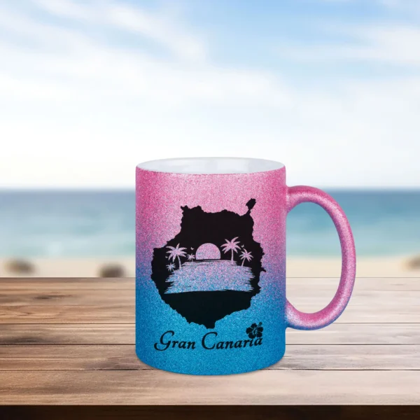 Glitzertasse Gran Canaria in pink-blau bedruckt mit Inselform in der ein Sonnenuntergang am Meer und Schriftzug Gran Canaria mit Hibiskus gezeigt ist